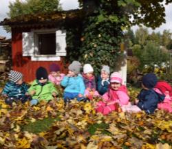 Kinder spielen mit Herbstlaub